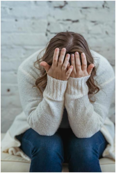 Unrecognizable tired female in casual clothes cove