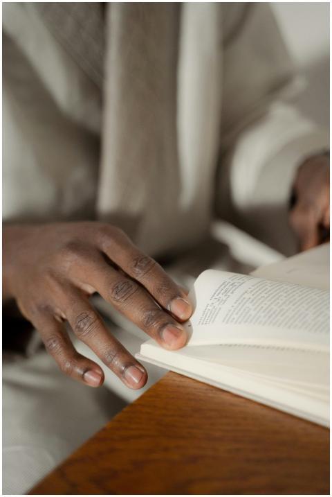 A close-up of a man's hands flipping through a boo