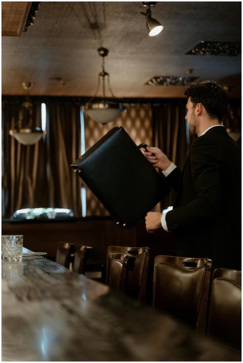 A professional man in a suit holds a briefcase in