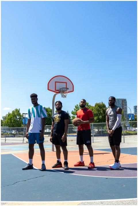 Four men standing on an outdoor basketball court u