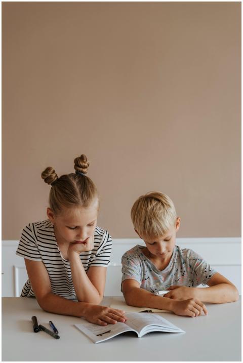 Two children focused on a book, emphasizing learni