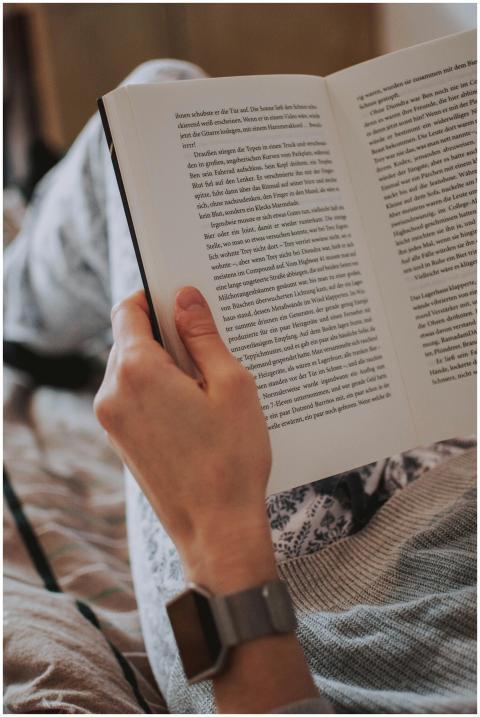 A relaxed scene of a person holding an open book,