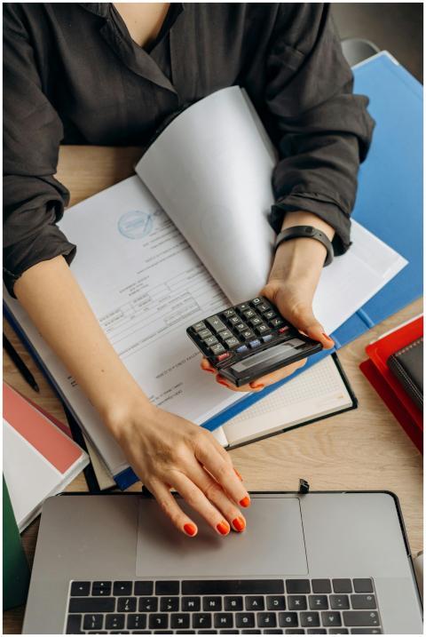 A business professional uses a calculator among do