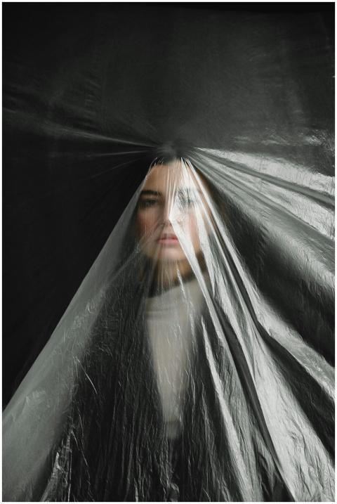 A striking portrait of a woman obscured by plastic