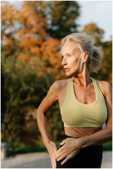 Elderly woman in sports bra practicing yoga outdoo