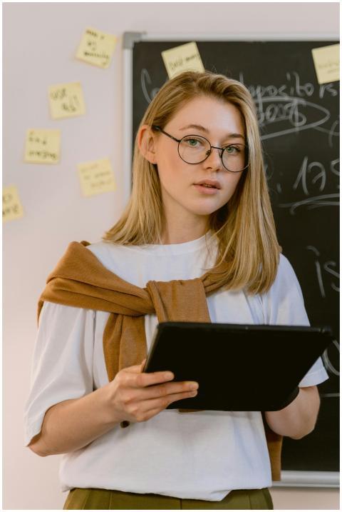 Caucasian woman standing in a classroom holding a