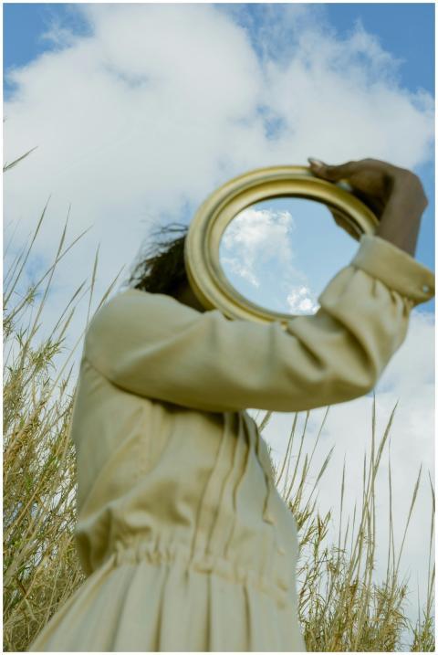 Artistic portrayal of a woman holding a mirror ref