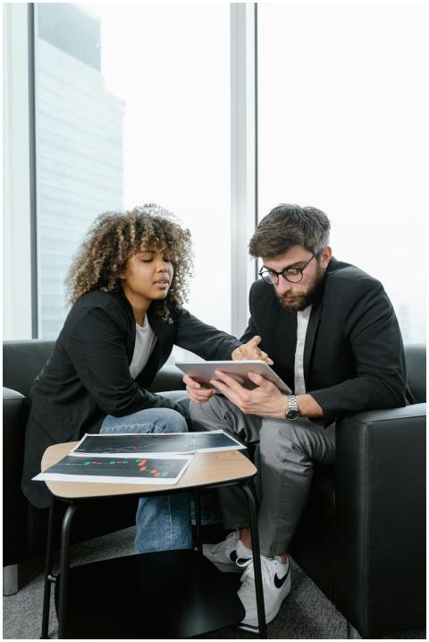 Two colleagues analyzing financial data and charts