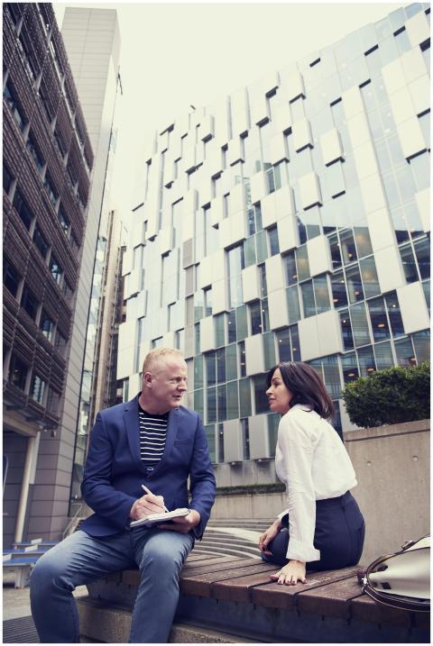 Two professionals discussing business outdoors sur