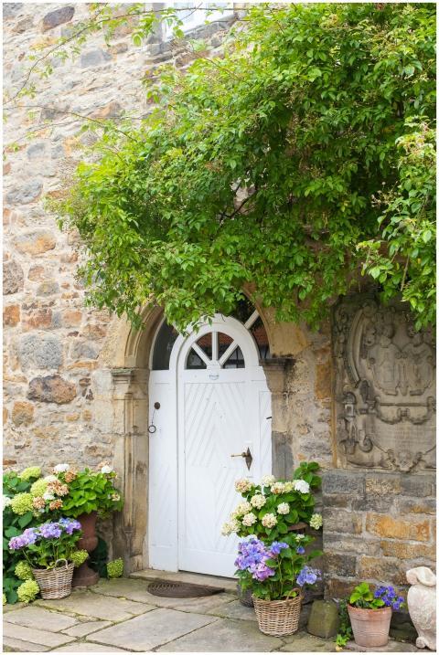 White door of a rustic stone cottage adorned with
