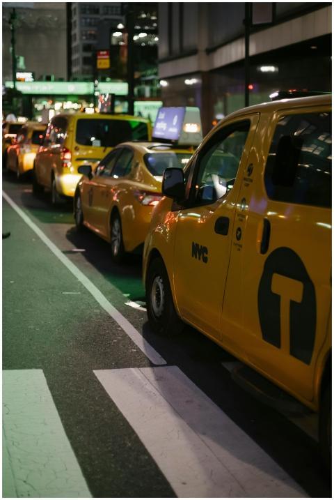 Yellow taxis line a bustling street in New York Ci