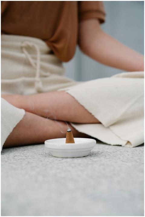 Close-up of a person meditating with incense burni