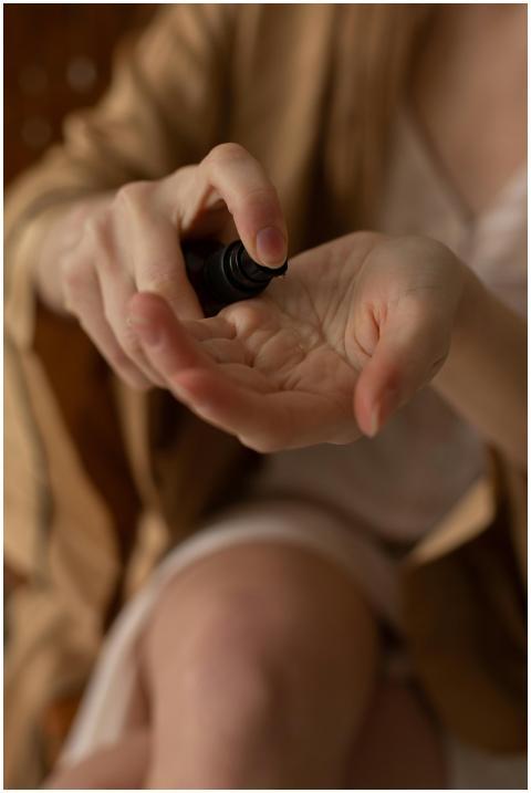 Close-up of hands applying skincare product from a