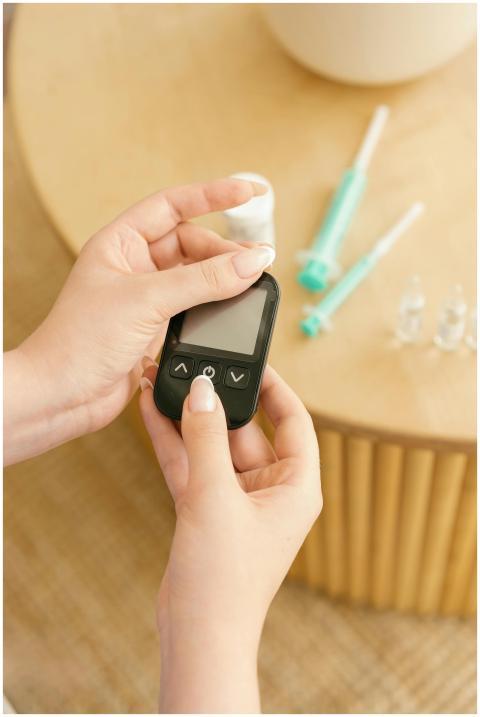 Close-up of hands holding a glucometer with medica