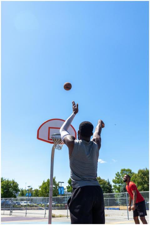 Players enjoying a basketball game outdoors on a s