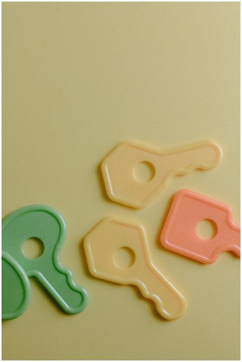 Close-up of colorful plastic toy keys on a yellow