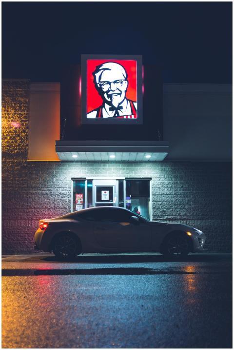 Dark car on paved roadway at window of drive thru
