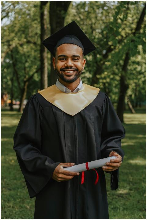A joyful graduate in cap and gown holding a diplom