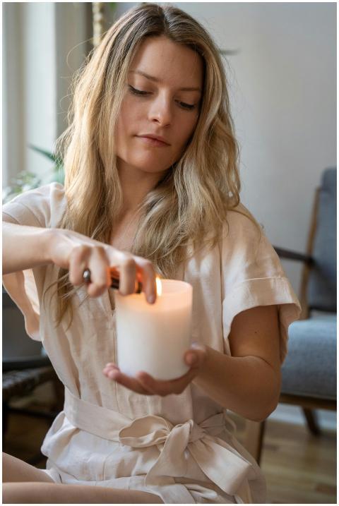 A serene moment capturing a woman lighting a candl
