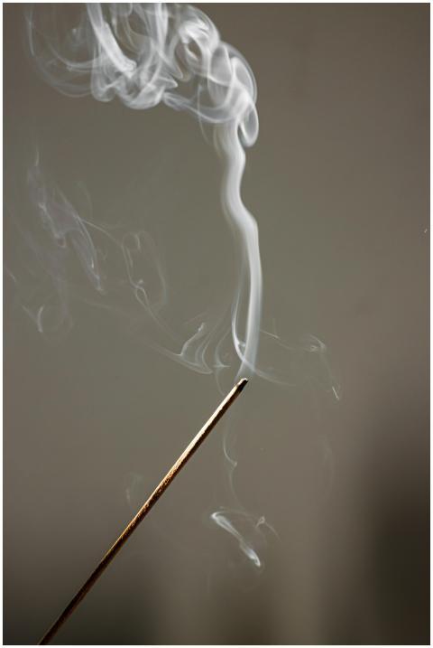 Close-up of incense stick emitting calming smoke,