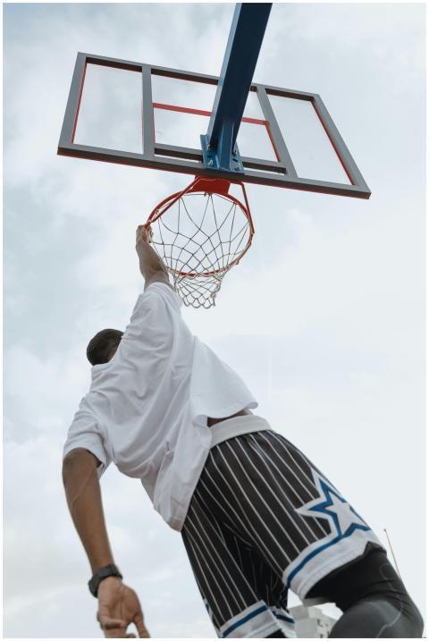 Low-angle shot of a man performing a basketball du