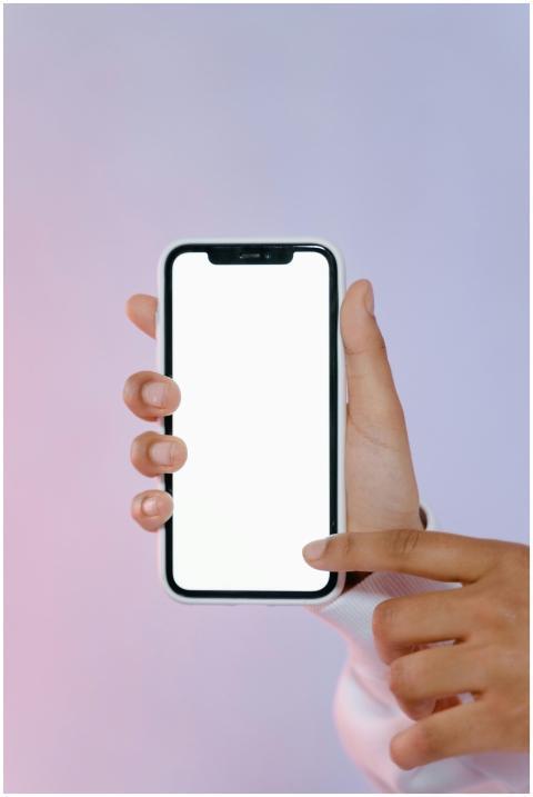 Close-up of hand holding smartphone with blank whi