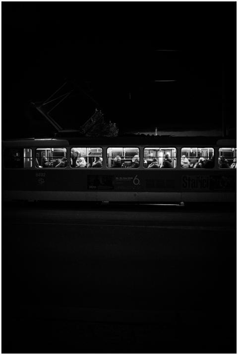 Dramatic black and white image of a tram at night