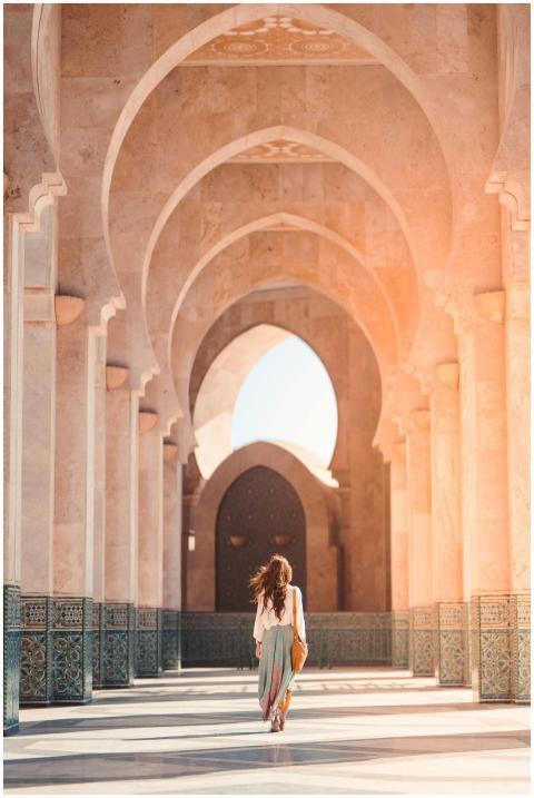 A woman walks through the stunning arches of Hassa
