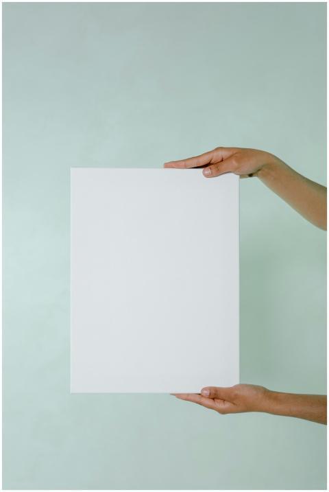 White blank card held by hands against a minimalis