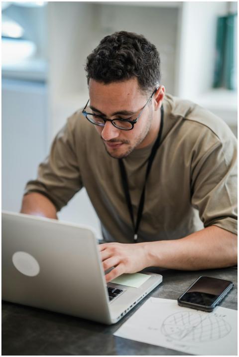 Man with eyeglasses working on laptop in a modern