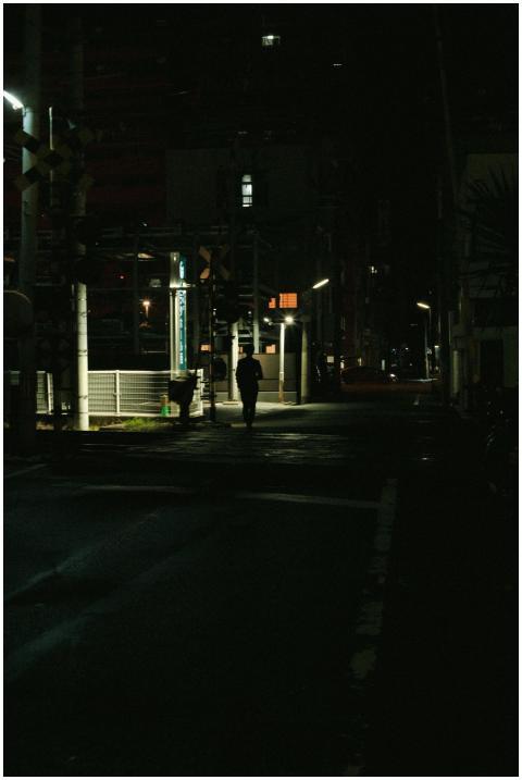 Silhouette of a lone figure walking through a dark