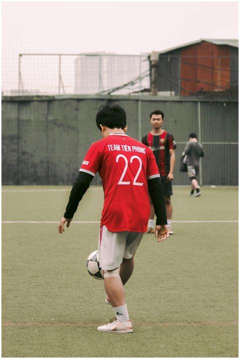 Back view of teenagers playing soccer in red jerse