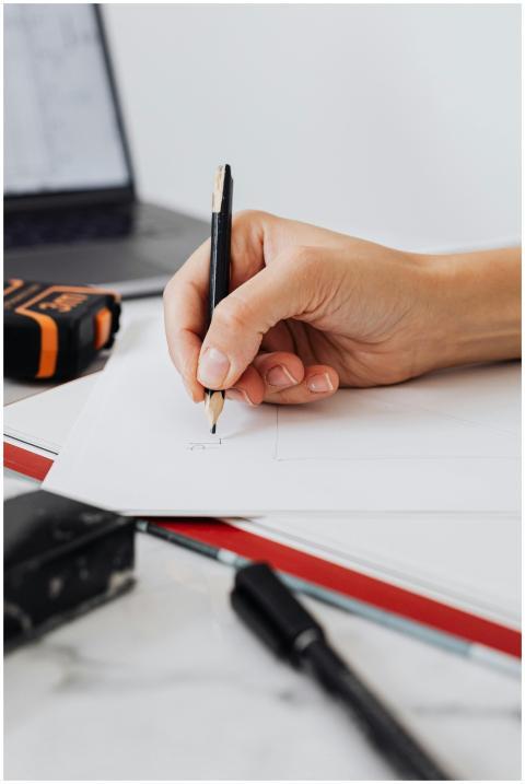 Hand drawing on paper with pencil in a focused wor