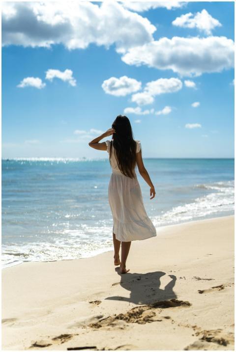 Woman in a white dress walking along Playa del Car