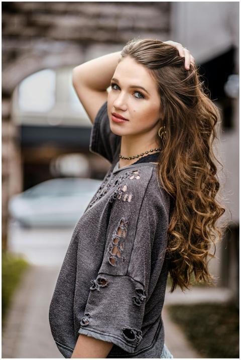 Stylish young woman with long hair poses confident