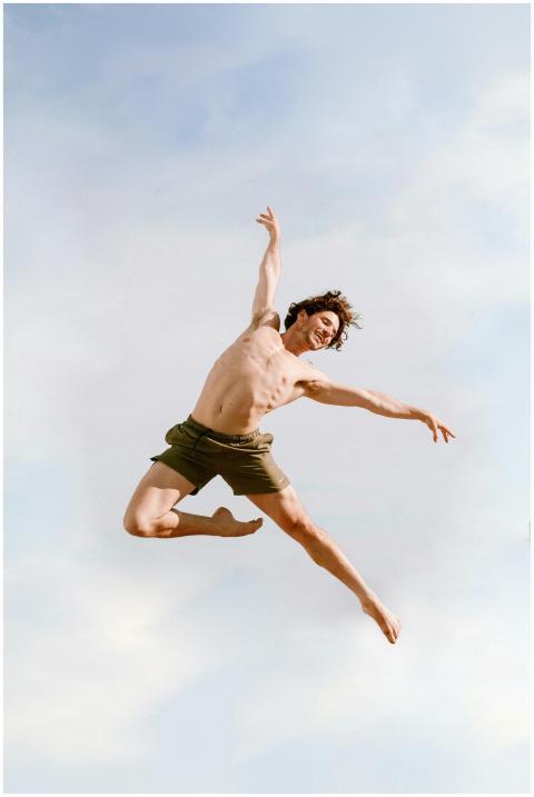 From below of cheerful ballet dancer with naked to