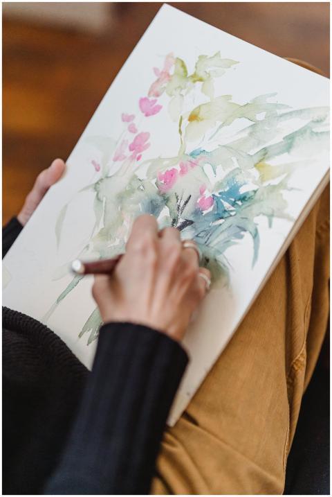 A person painting delicate floral watercolor art i