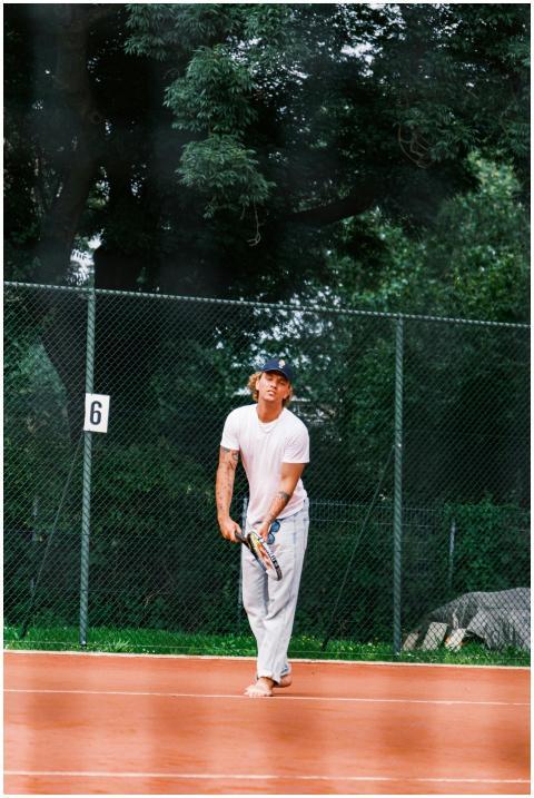 Adult male tennis player in action on outdoor clay