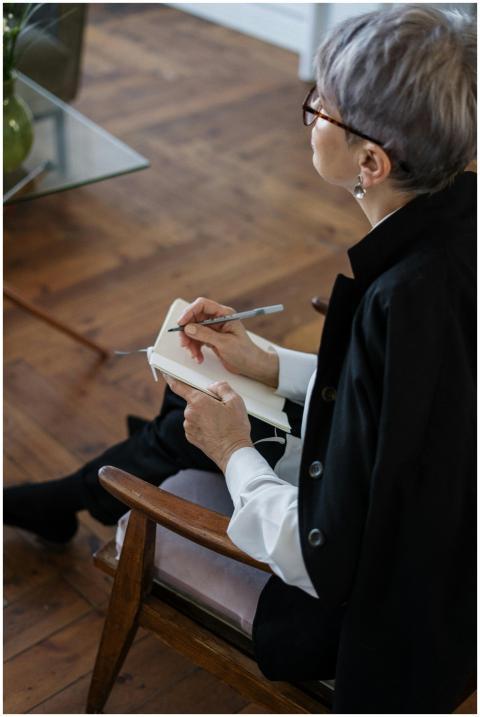 A professional woman with glasses taking notes whi