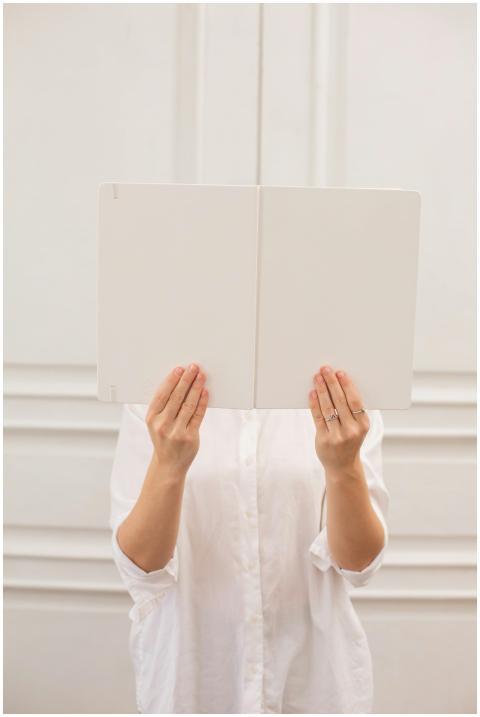 Unrecognizable female in white blouse hiding face