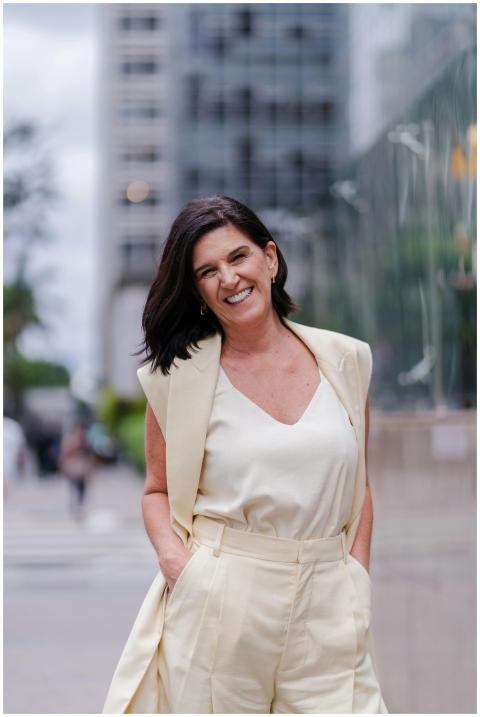 Smiling woman in a cream outfit posing confidently