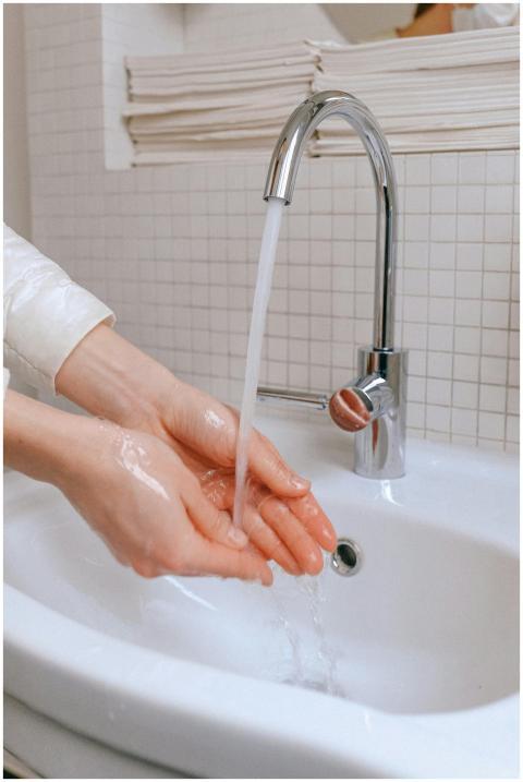 Close-up of hands being washed under running water
