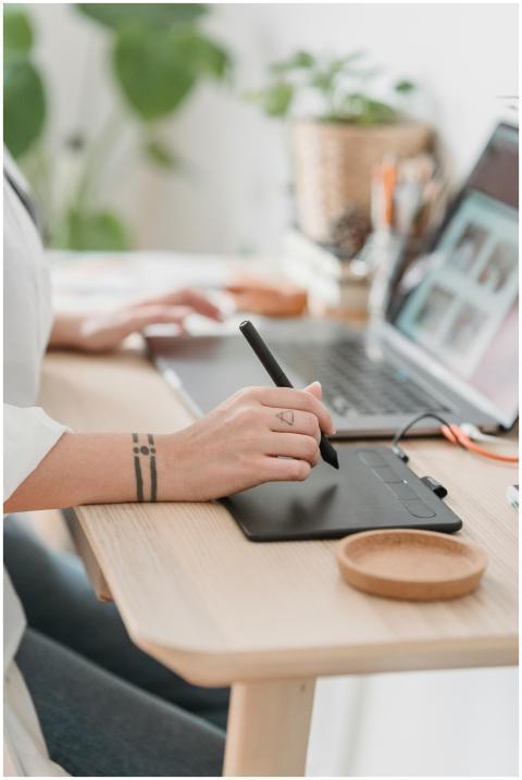 Crop anonymous female browsing netbook and working