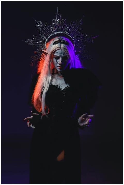 Eerie woman in elaborate costume and headdress wit