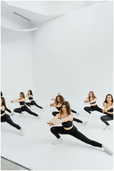 A group of women in black dance wear performing a