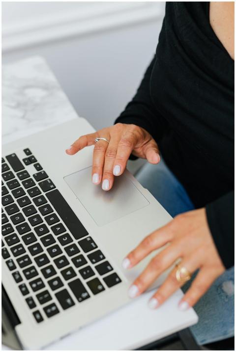 Close-up of a woman using a laptop touchpad in a m