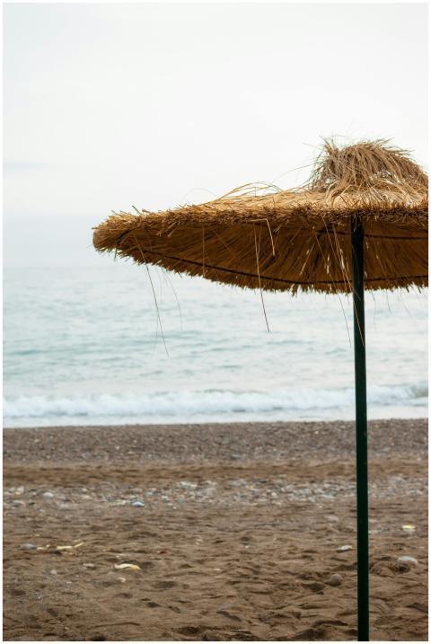 A tranquil beach with a thatched umbrella, showcas