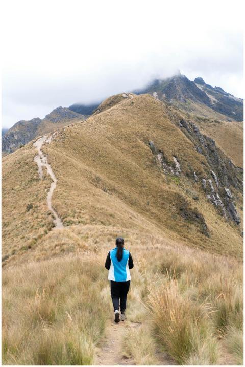 A woman hiking on a scenic mountain trail in the A