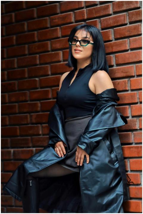 Stylish woman in sunglasses and black outfit leani