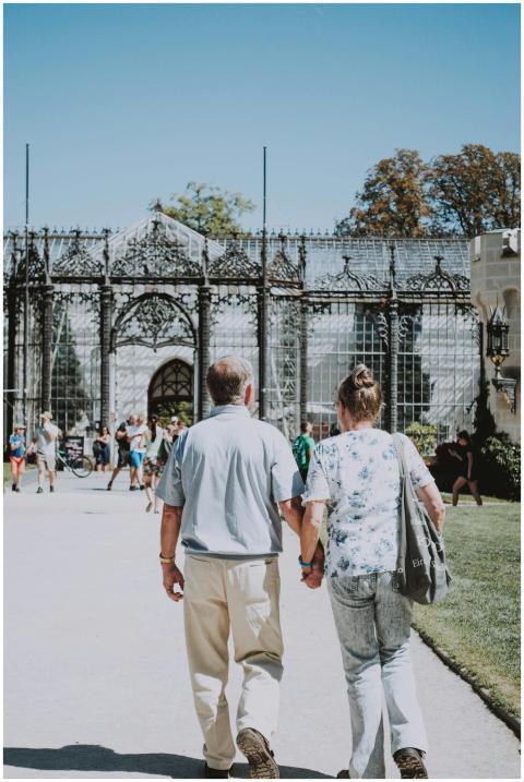 A couple holding hands strolling by a historic got